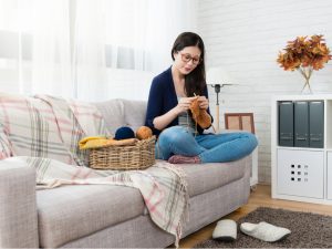 woman knitting on couch